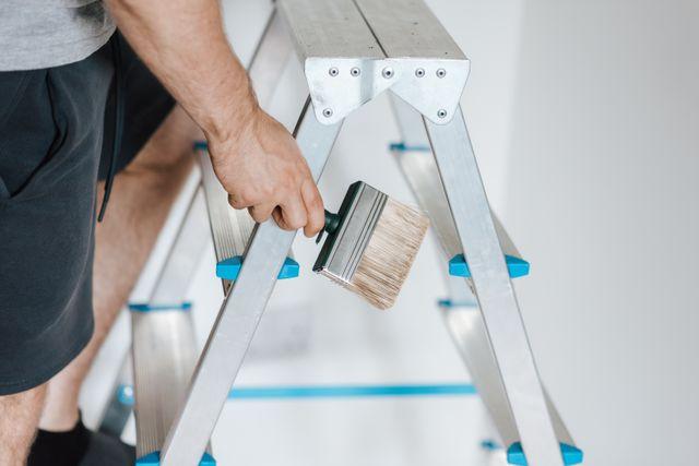 a person on a ladder with a paintbrush